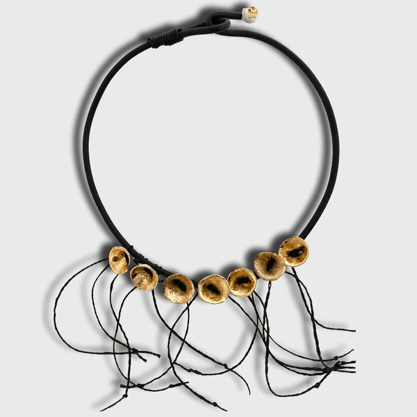 Collier noir en cordon avec disques dorés percés et petits fils noirs pendants