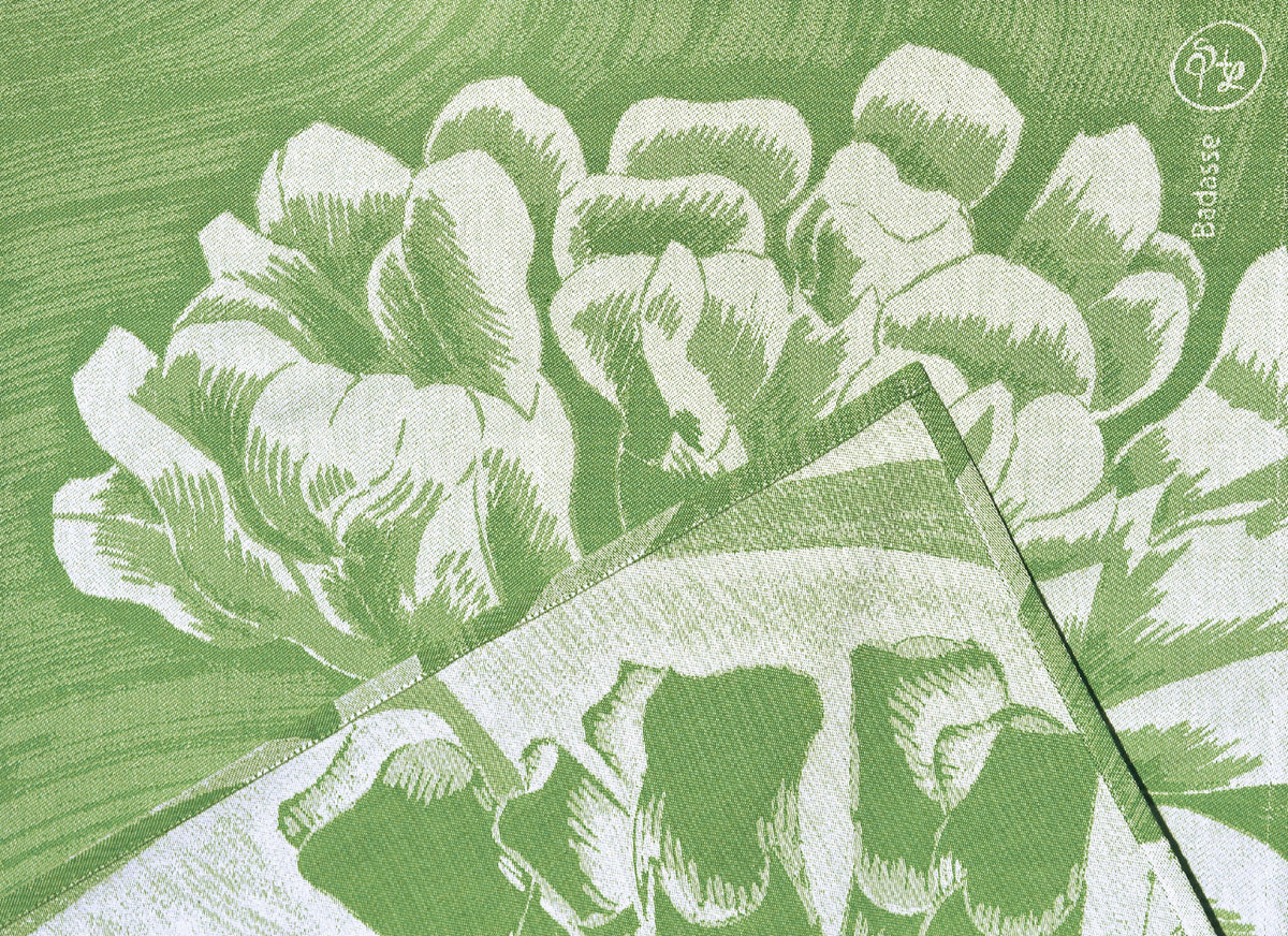 Détail du torchon : motif floral blanc sur fond vert, texture tissée