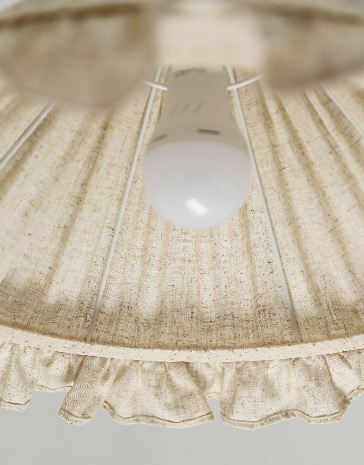 Intérieur de l’abat-jour conique en lin et coton beige à volant froncé