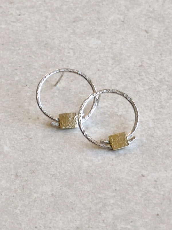 Boucles d’oreilles créoles argentées avec pastille carrée dorée, vue rapprochée