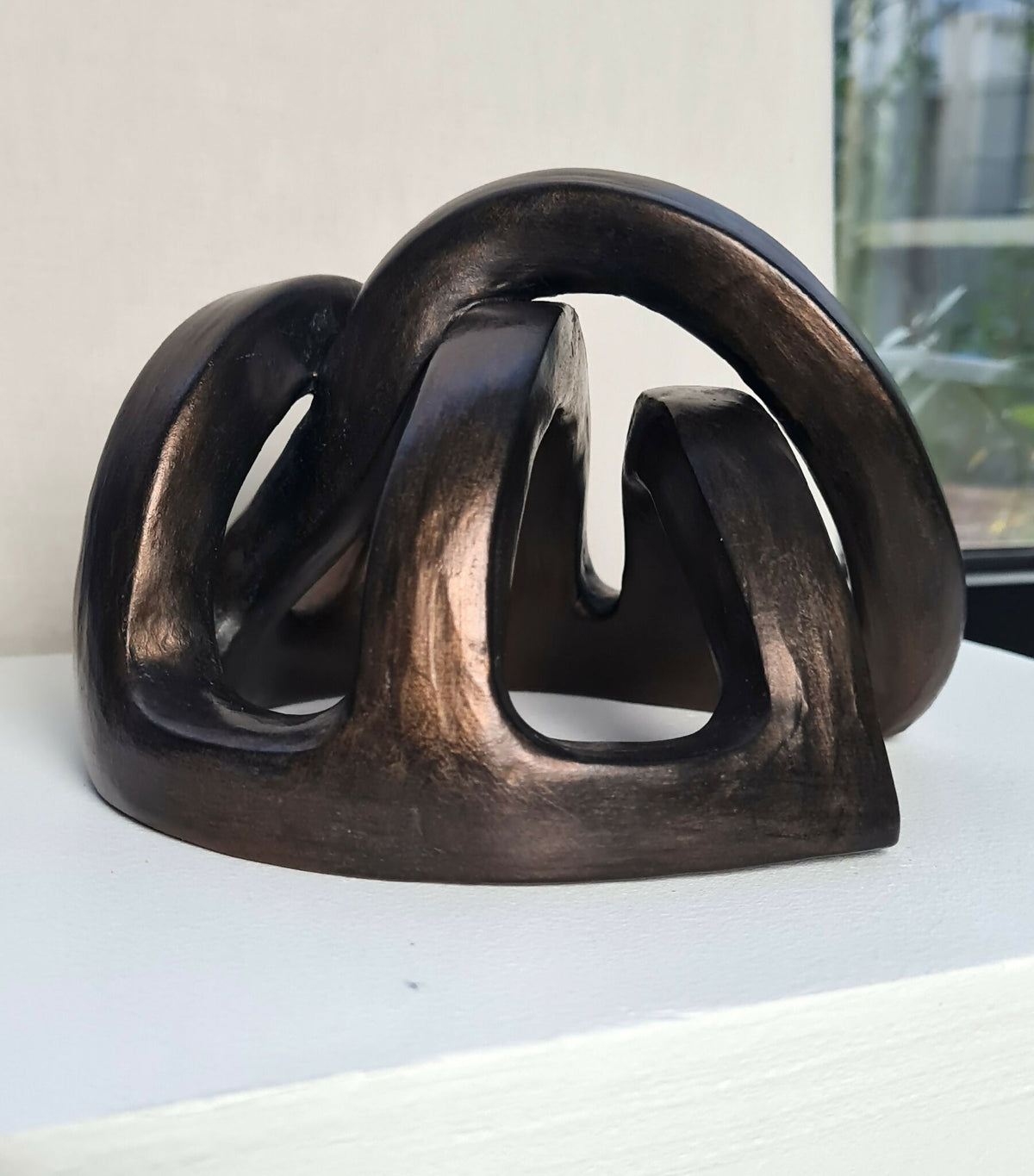 Sculpture abstraite en métal noir et brun, composition ouverte sur base arrondie
