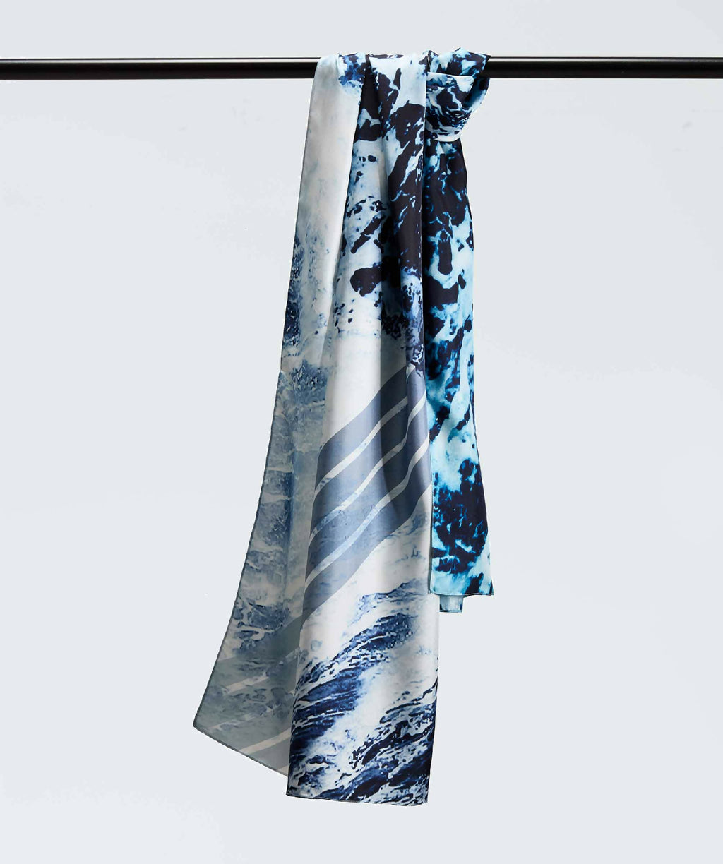 Écharpe bleue et noire à motif abstrait, drapée sur une barre