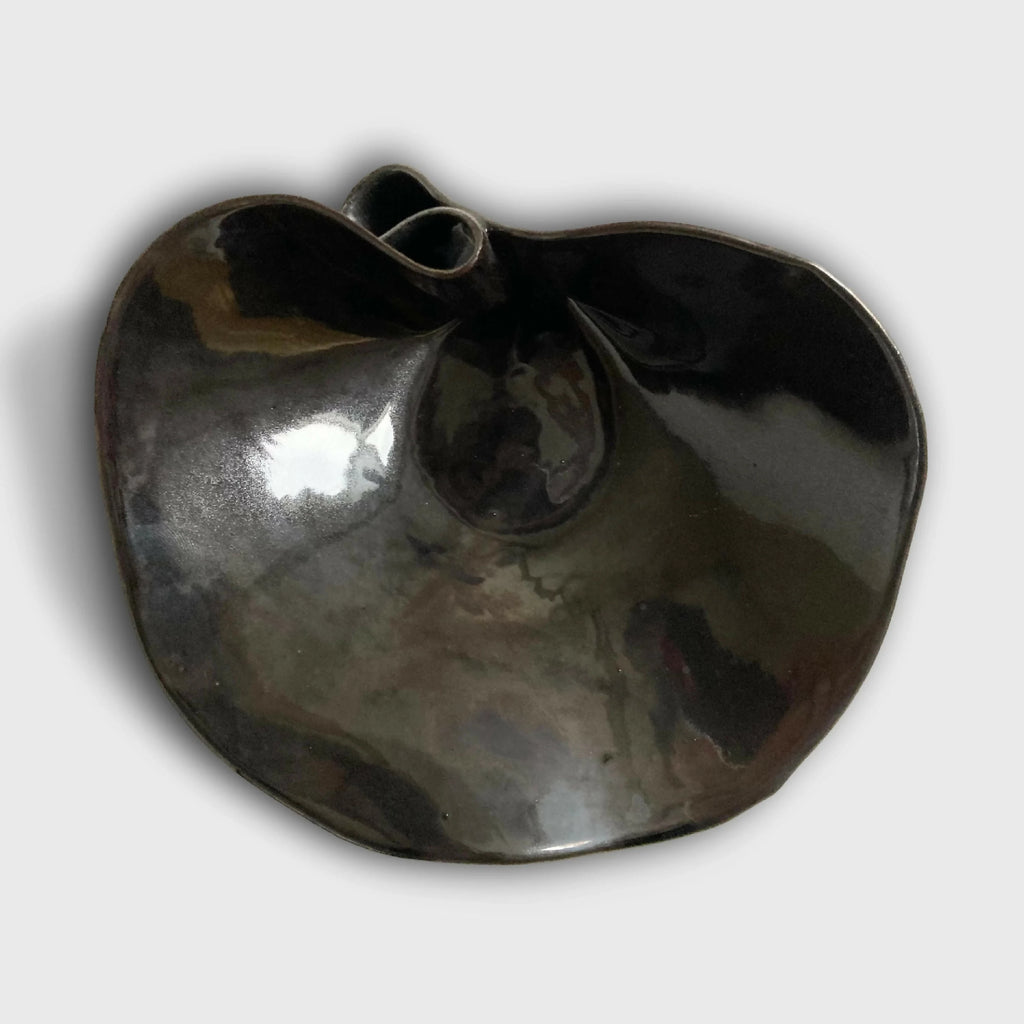 Coupe nénuphar noire en métal brillant, forme ovale avec rebords ondulés.