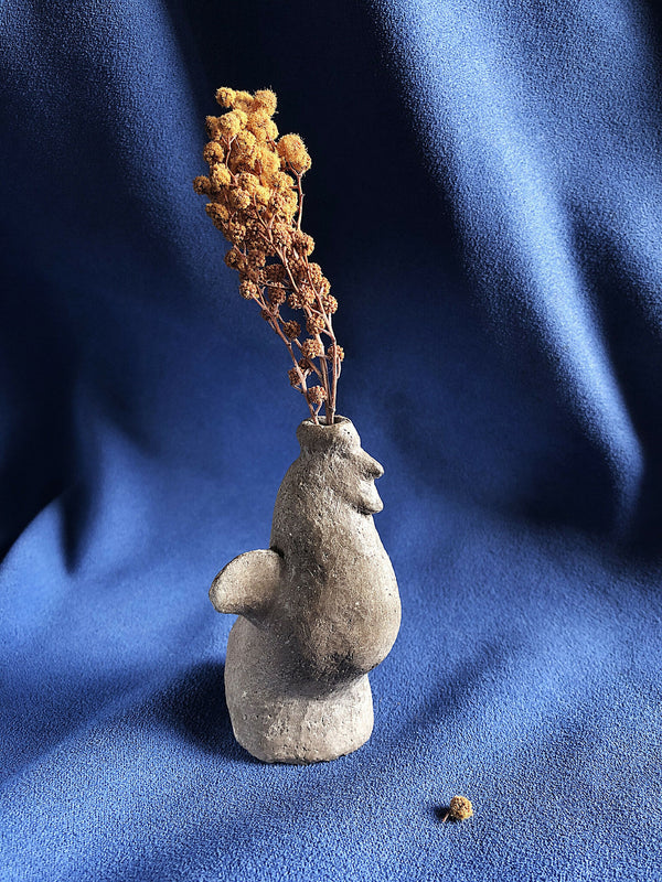 Petit vase à herbes sèches en céramique grise, forme sculptée, tiges brunes séchées