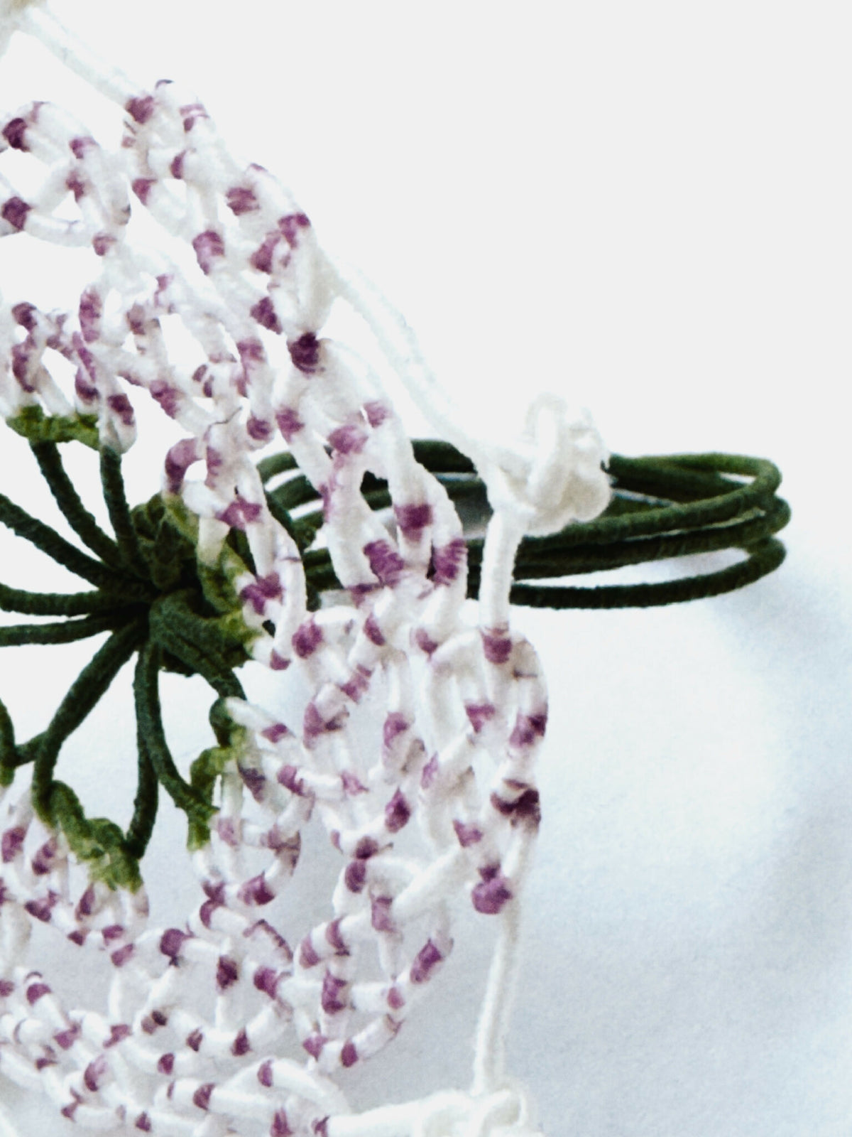 Bague en perles rosées et blanches, motif trèfle vert, détails de tresses blanches