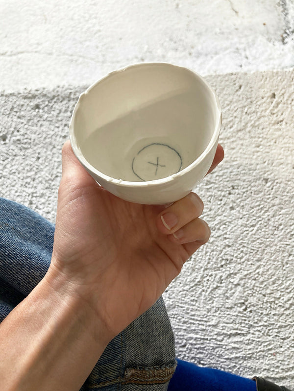 Tasse en porcelaine blanche, vue intérieure avec symbole en forme de croix