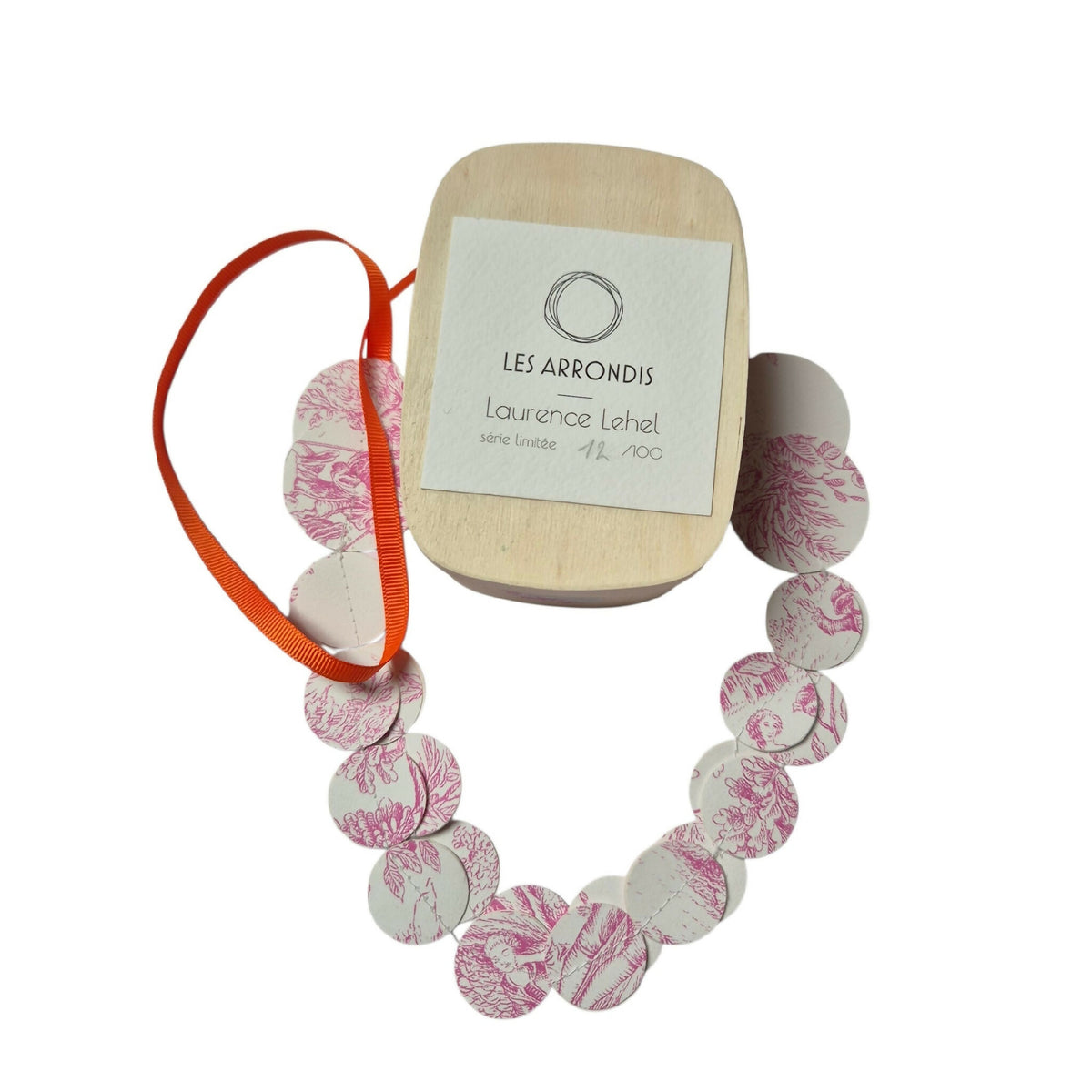 Collier en disques ronds rose à motifs, avec boîte beige et ruban orange