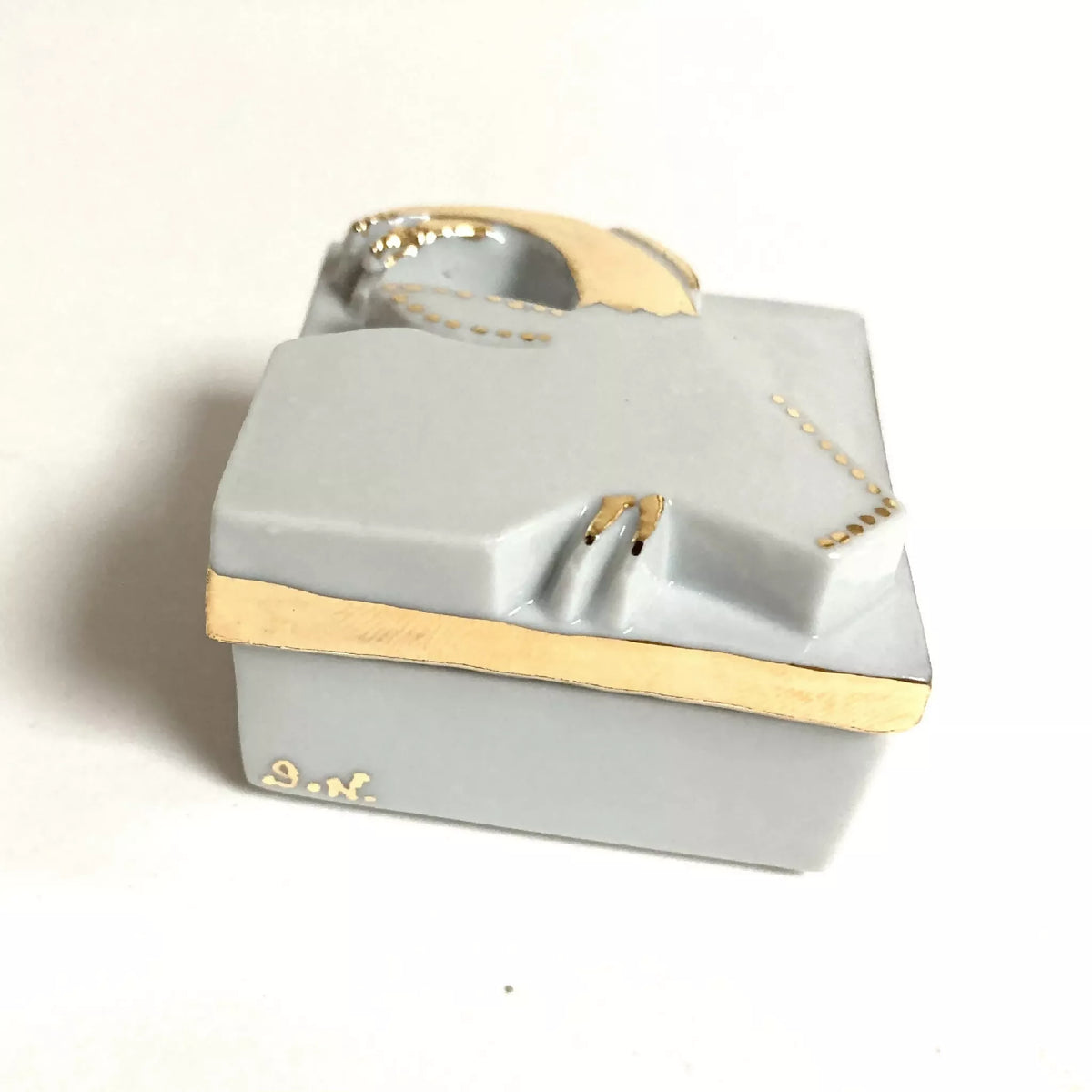 Boîte à bijoux en porcelaine blanche ouverte, bord doré et motif capricorne