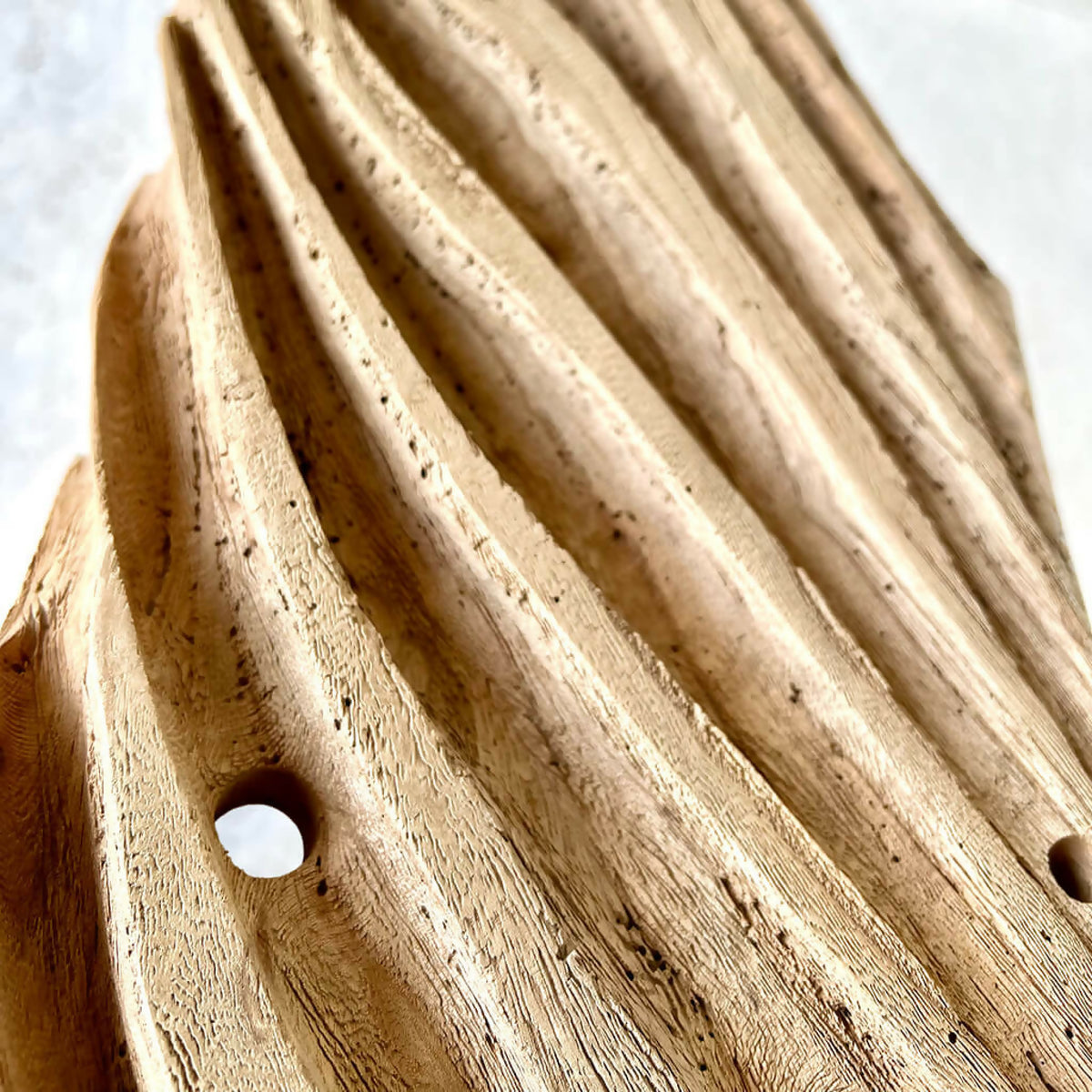 Décoration en bois brun striée, grand trou rond, petits points noirs