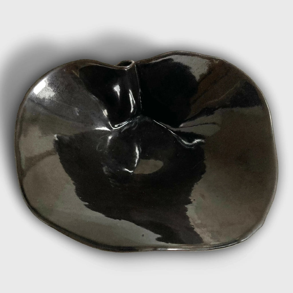 Coupe nénuphar noire en métal brillant, ouvertures au centre et volume arrondi.