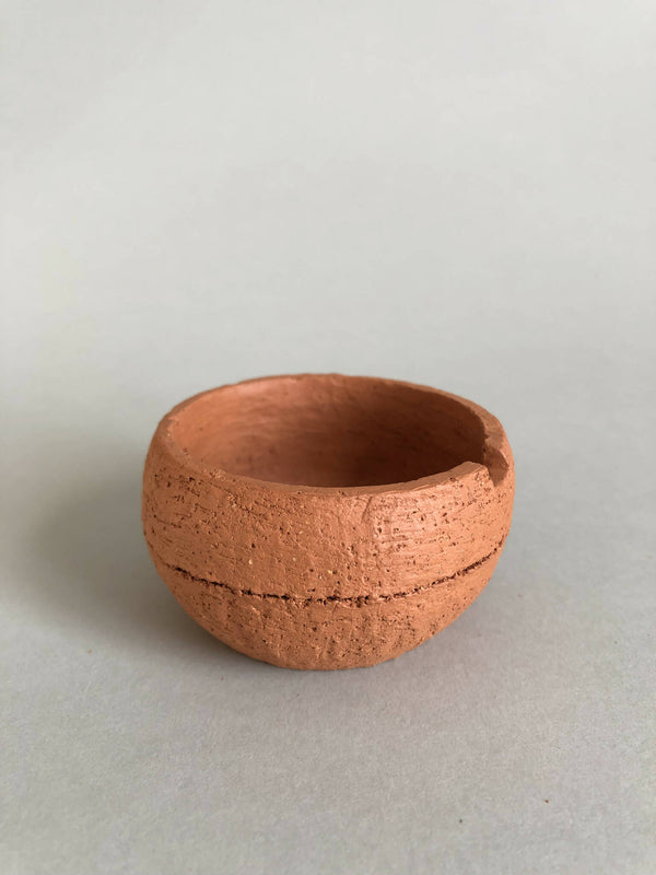 Petit pot en argile terracotta avec bord irrégulier et ouverture circulaire