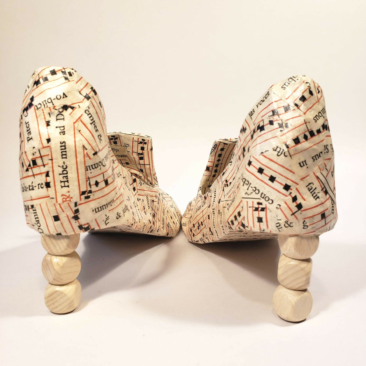 Escarpins beige imprimés, vue sur le dessus et la semelle, portés sur supports.