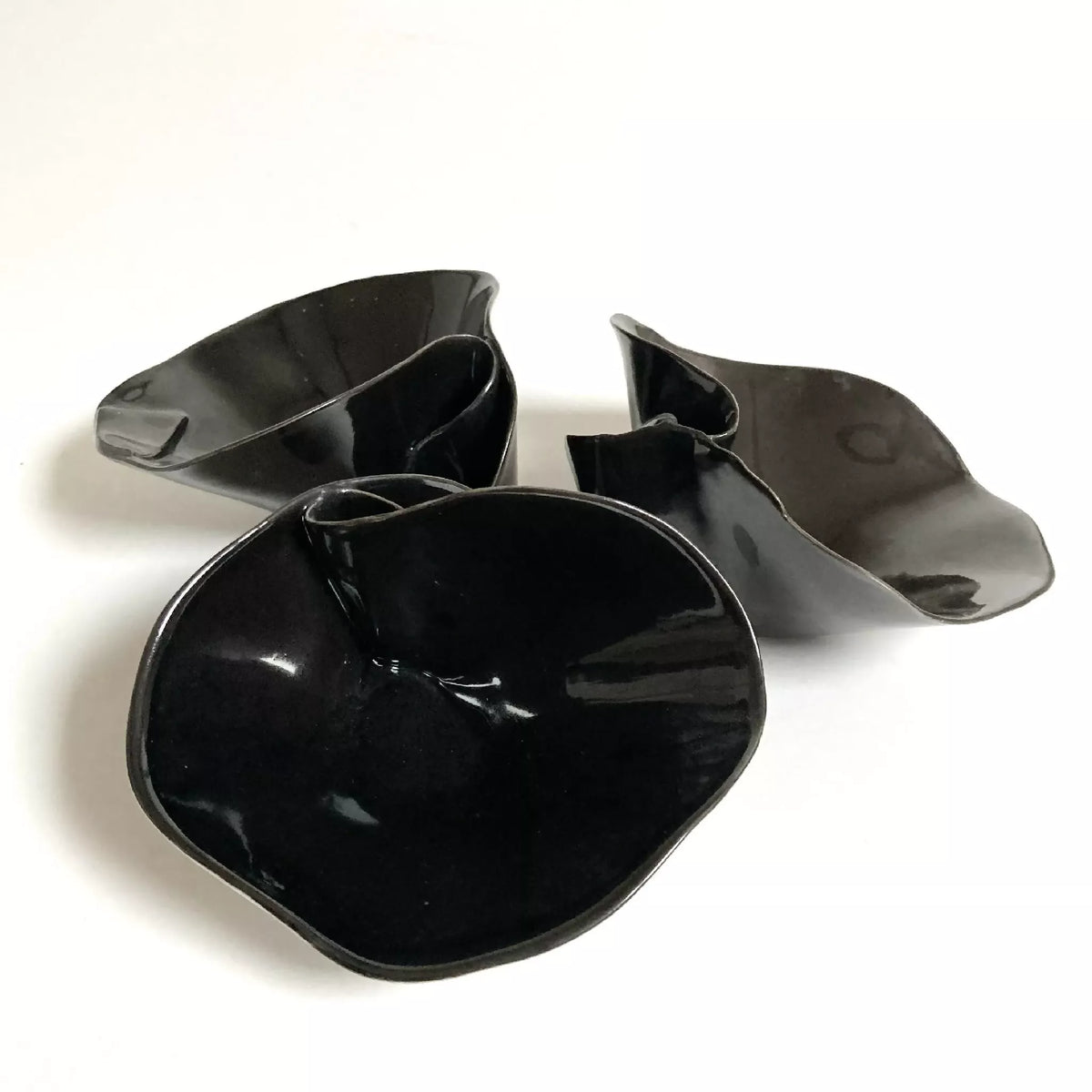 Trois coupelles nénuphar noires brillantes, formes de pétales ouvertes et creux central