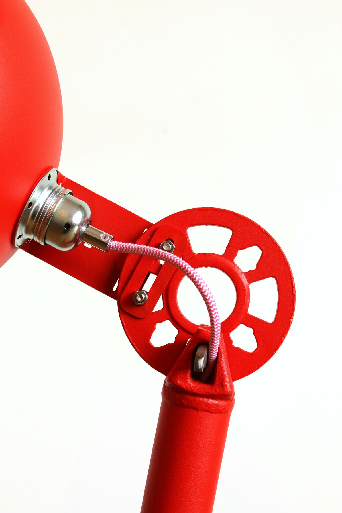 Lampe rouge : base E27 et câble tressé sur montage métallique près de l’axe