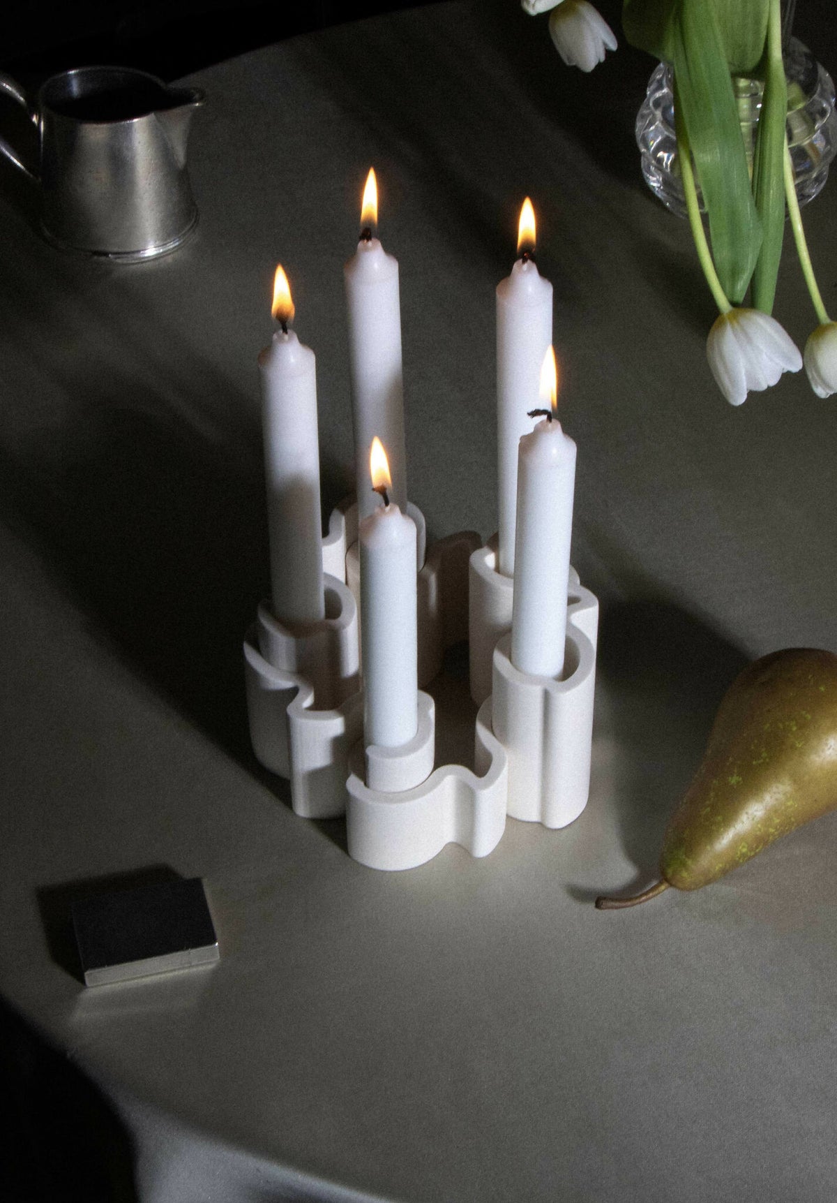 Chandelier à bougies allumées, support blanc en forme d’anneau pour 5 cierges.