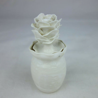 Vase en céramique blanc, silhouette cylindrique et décoration florale en relief.