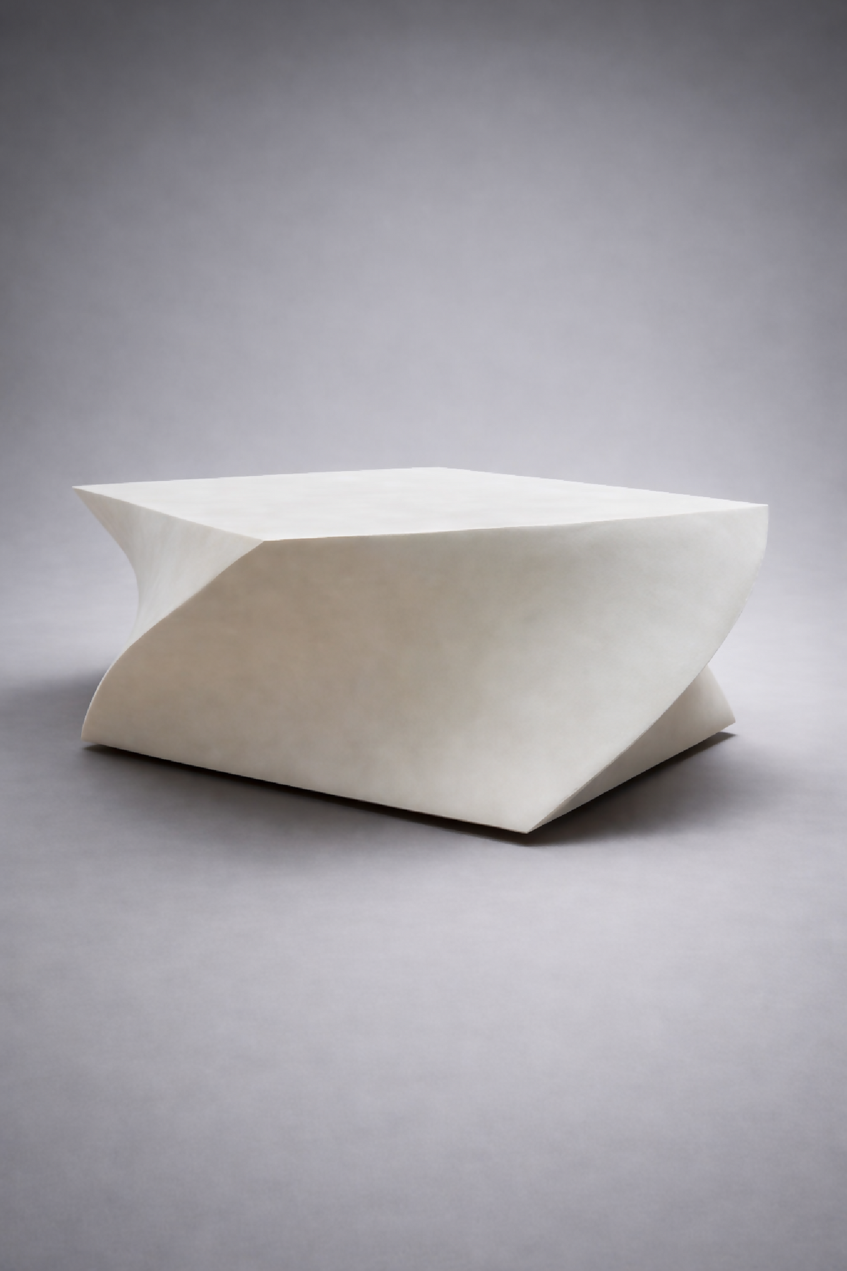 Table basse blanche aux lignes organiques, plateau rectangulaire incliné, vue trois-quarts.
