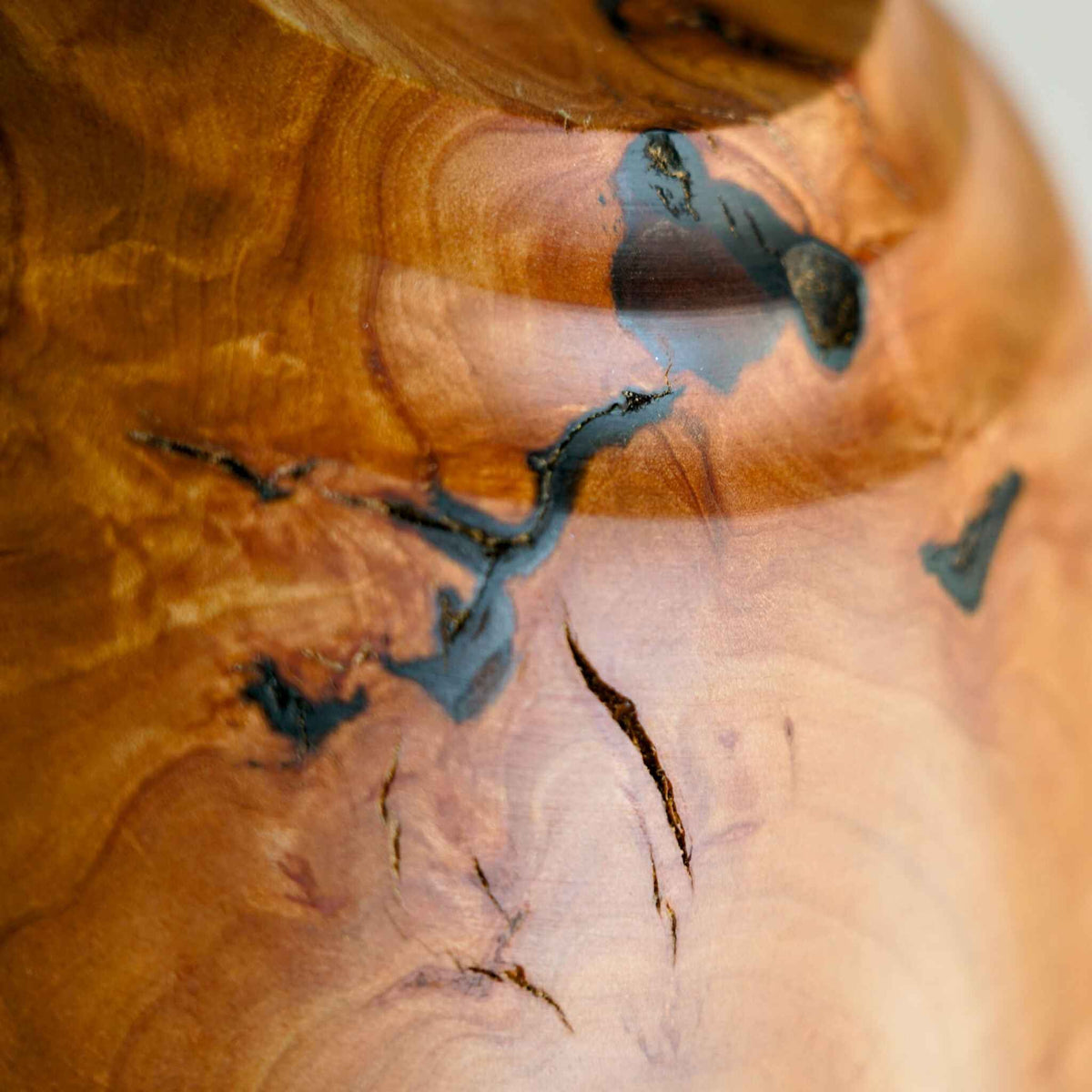 Saladier en bois de poirier, gros plan sur veines, fissures et nœuds bleu-noir