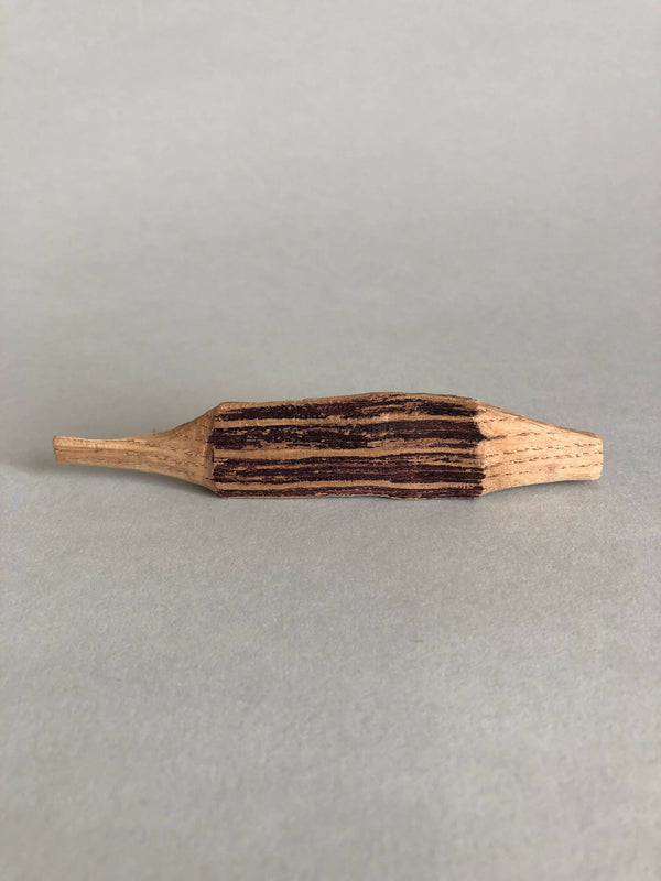 Petite forme en bois peinte, baguette allongée aux motifs sombres striés