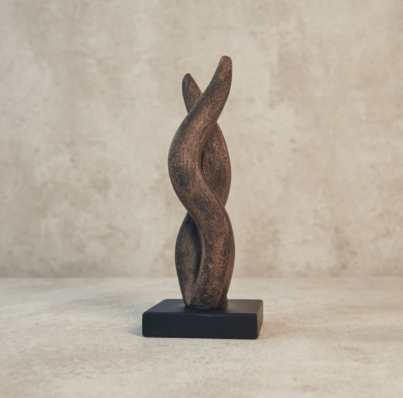 Sculpture contemporaine en métal patiné, forme de flamme abstraite sur socle noir.