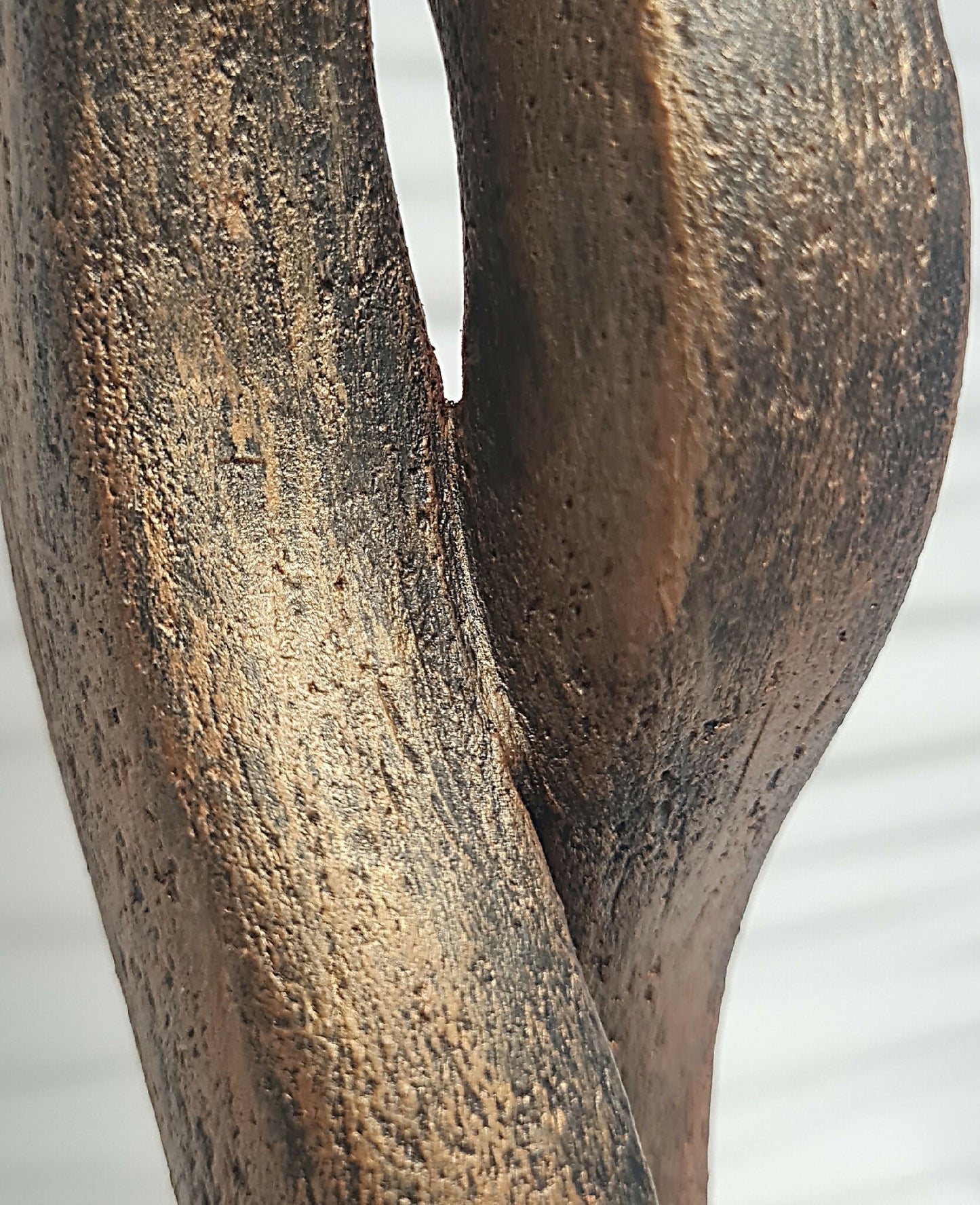 Détail de la sculpture en bronze texturé, forme de flamme, vue rapprochée