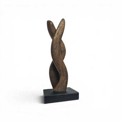 Sculpture en bronze en forme de flamme, posée sur un socle noir