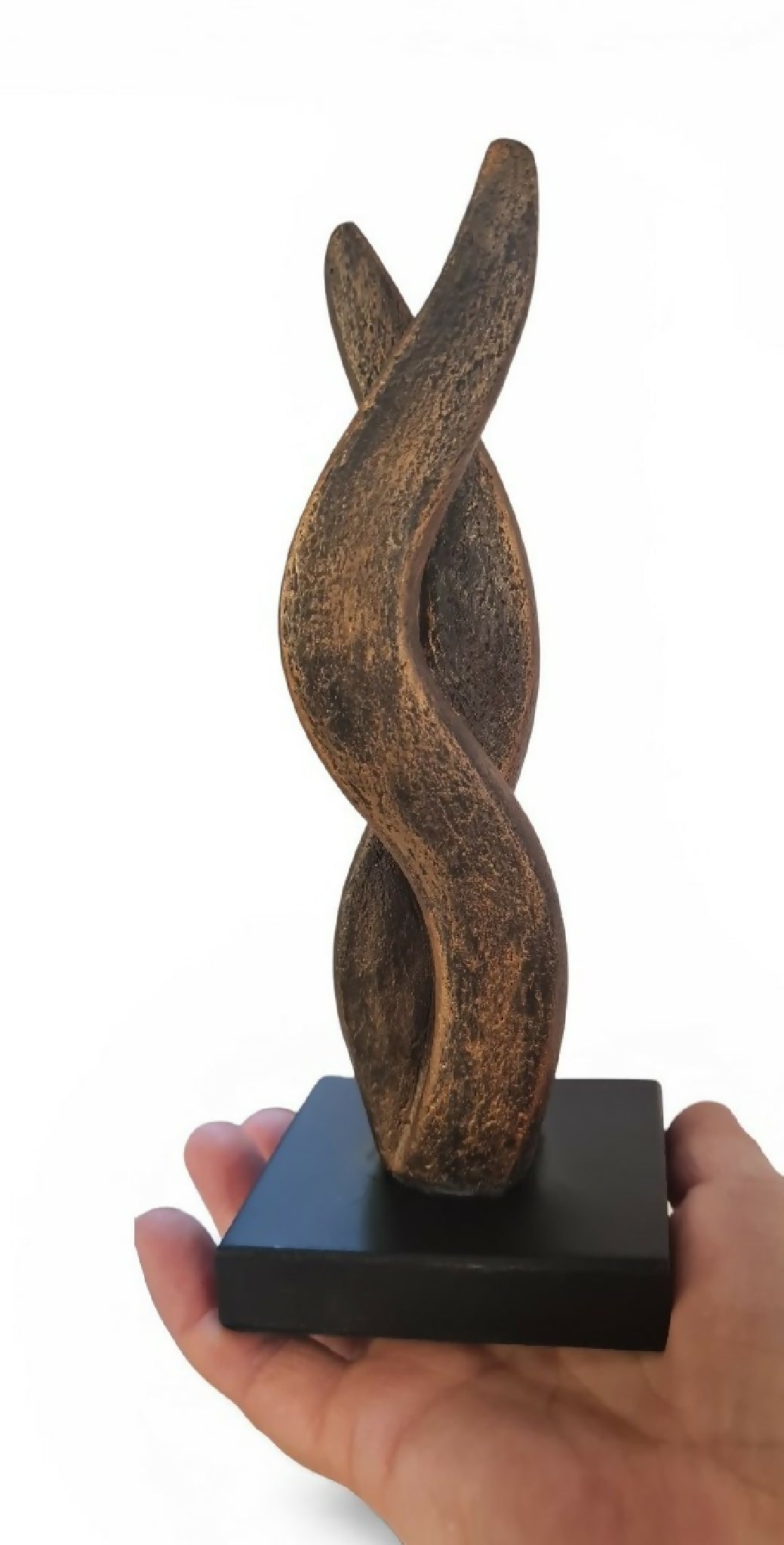 Sculpture bronze en forme de flamme, tenue par une main, sur socle noir
