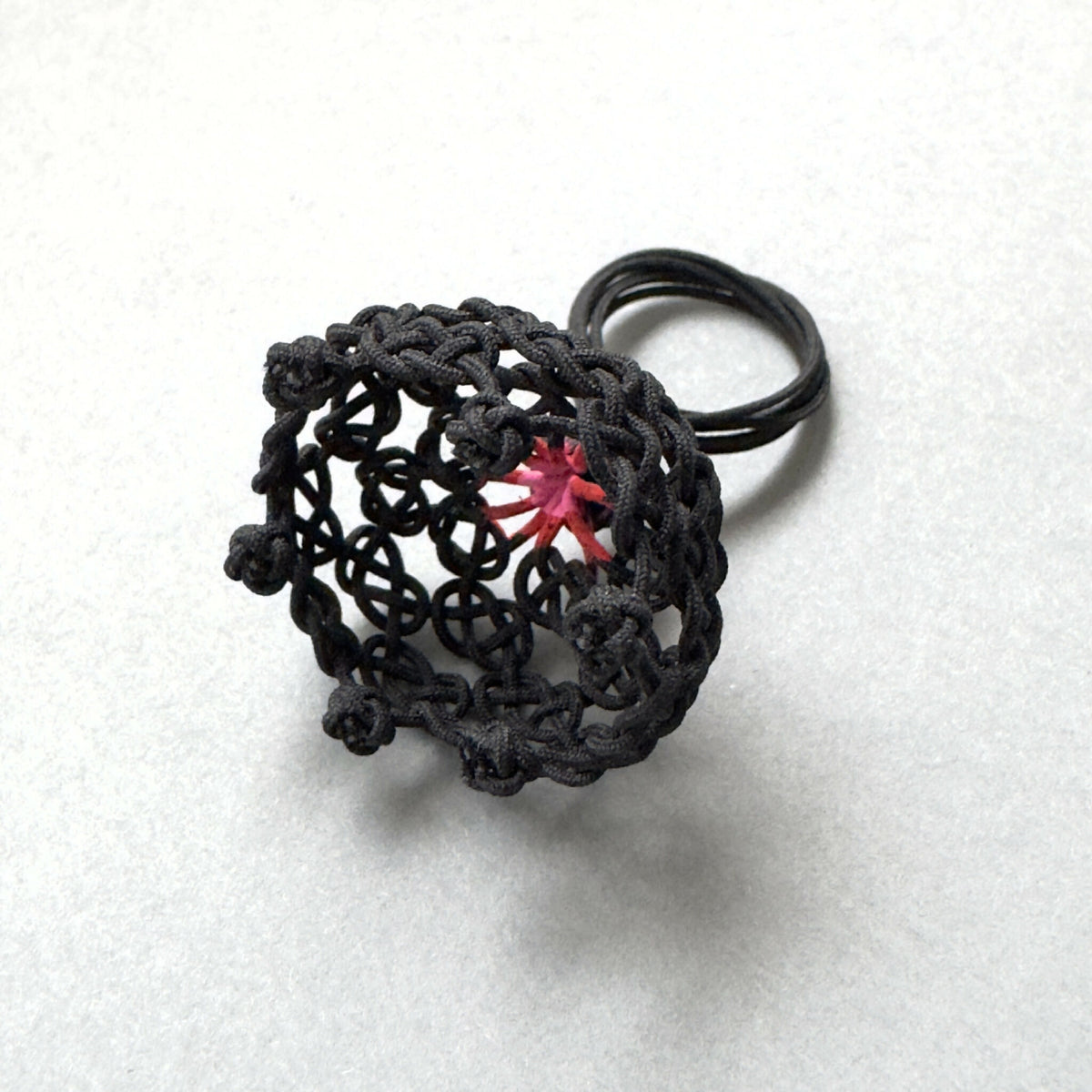 Bague noire en résille tressée, motif étoile rouge au centre