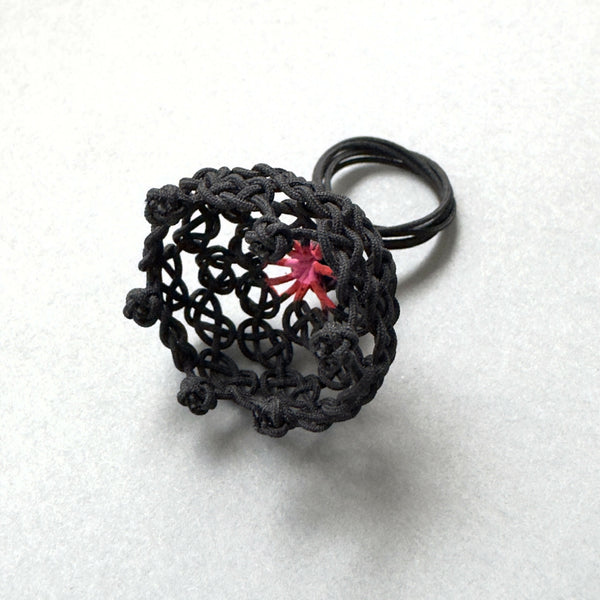 Bague noire en résille tressée, motif étoile rouge au centre