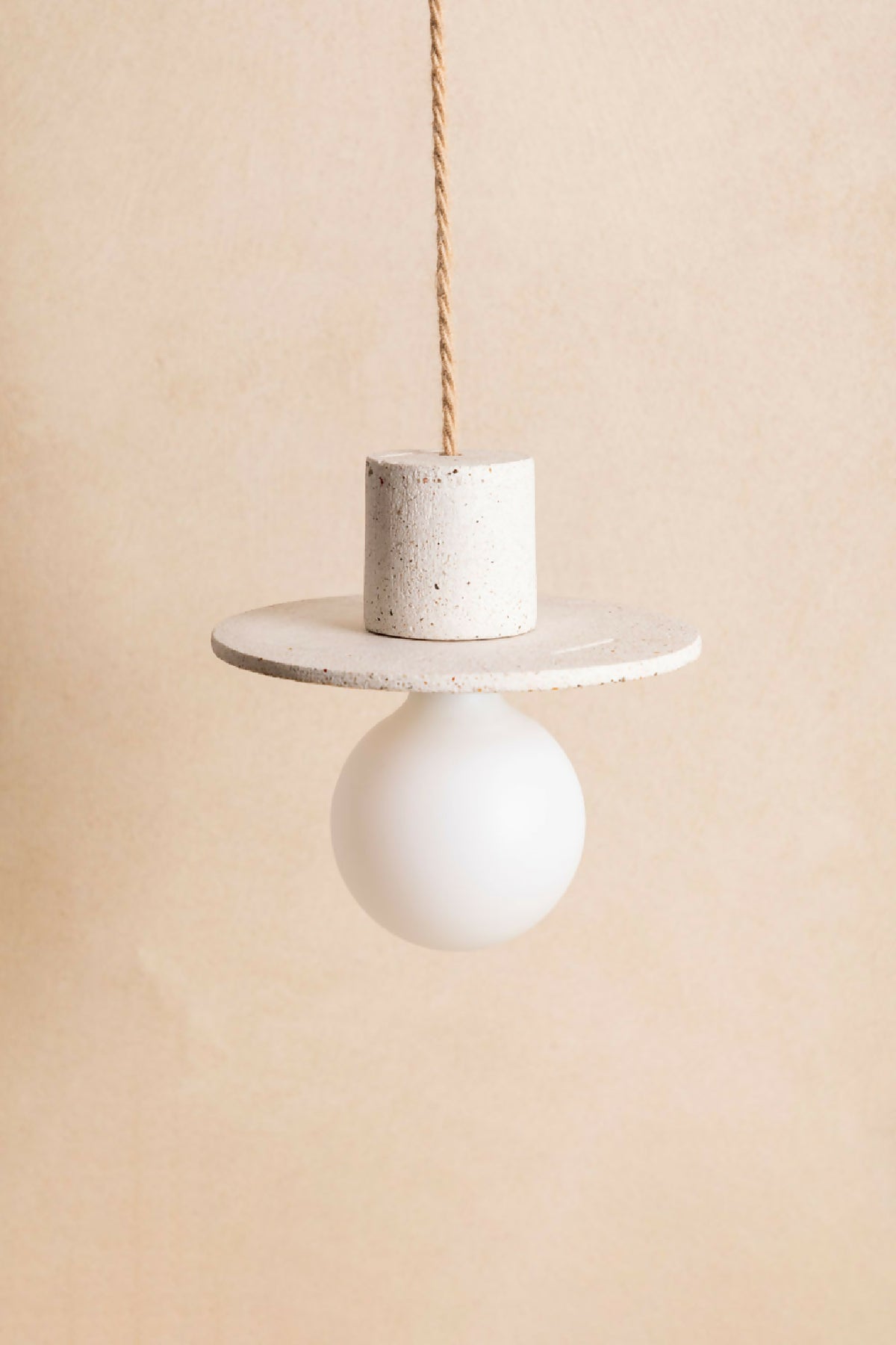 Suspension à globe blanc et cylindre effet béton blanc moucheté, câble torsadé doré