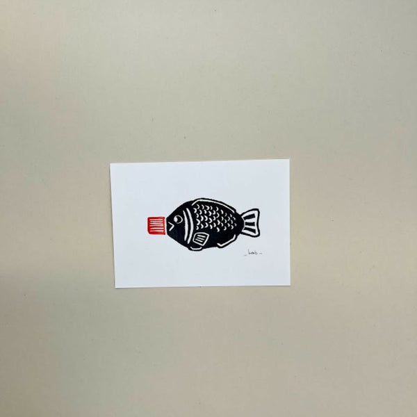 Linogravure A6 10×15 cm : poisson noir et étiquette rouge, sur fond blanc.