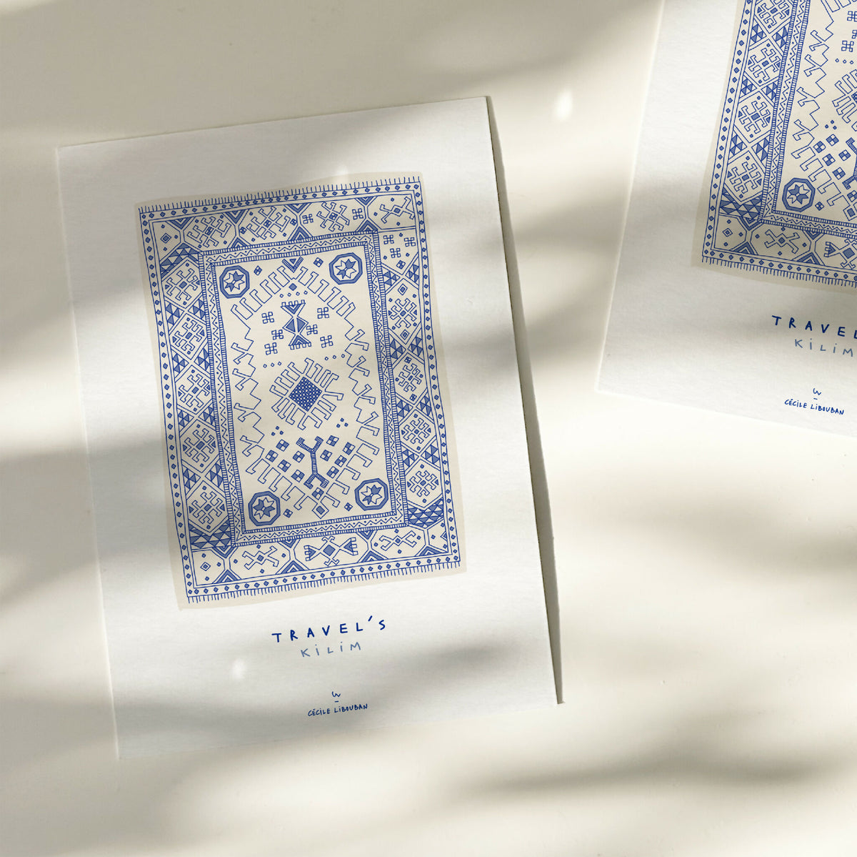 Carte illustrée bleue à motif kilim encadré, typographie « TRAVEL'S KILIM »