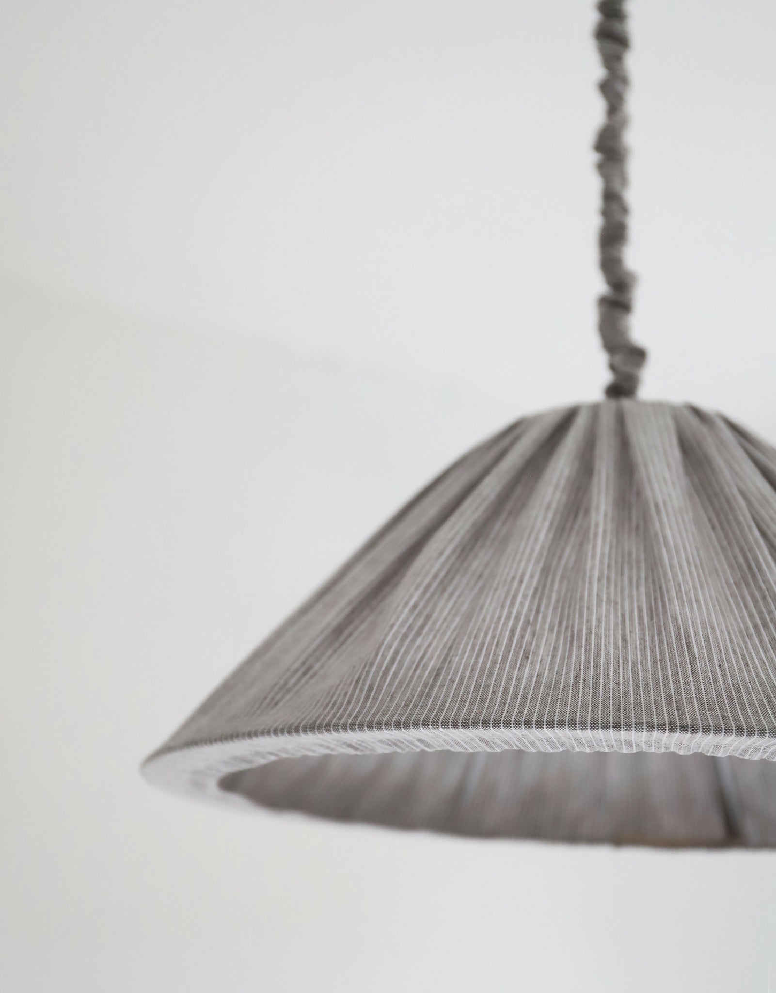 Abat-jour plissé gris à fines rayures, détail du bord et de la couture