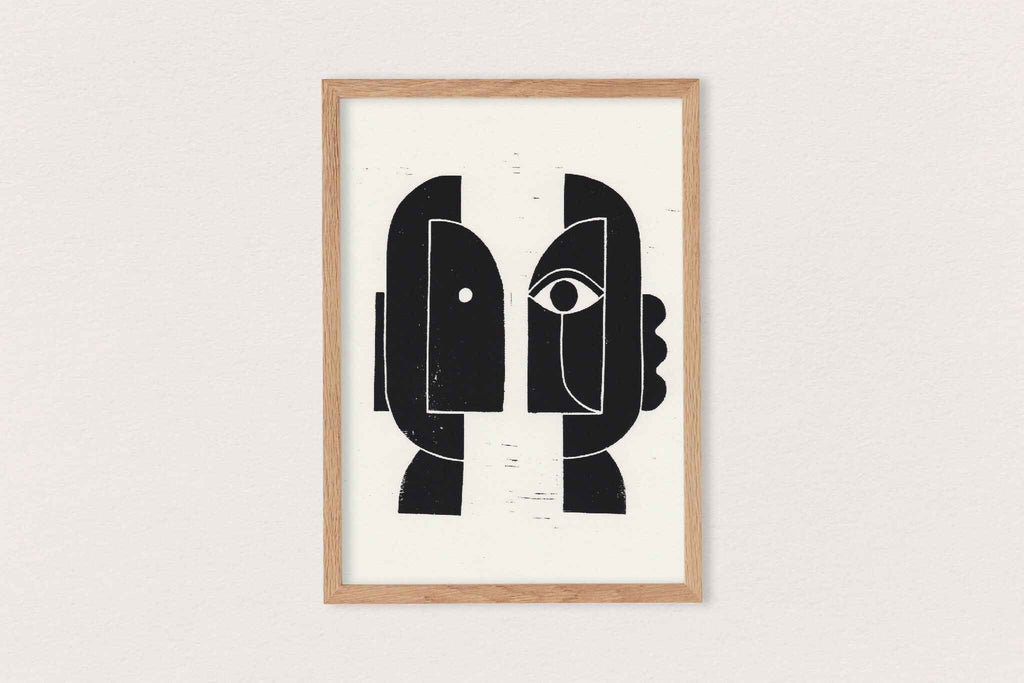 Linogravure encadrée, composition noire de visages stylisés sur fond clair