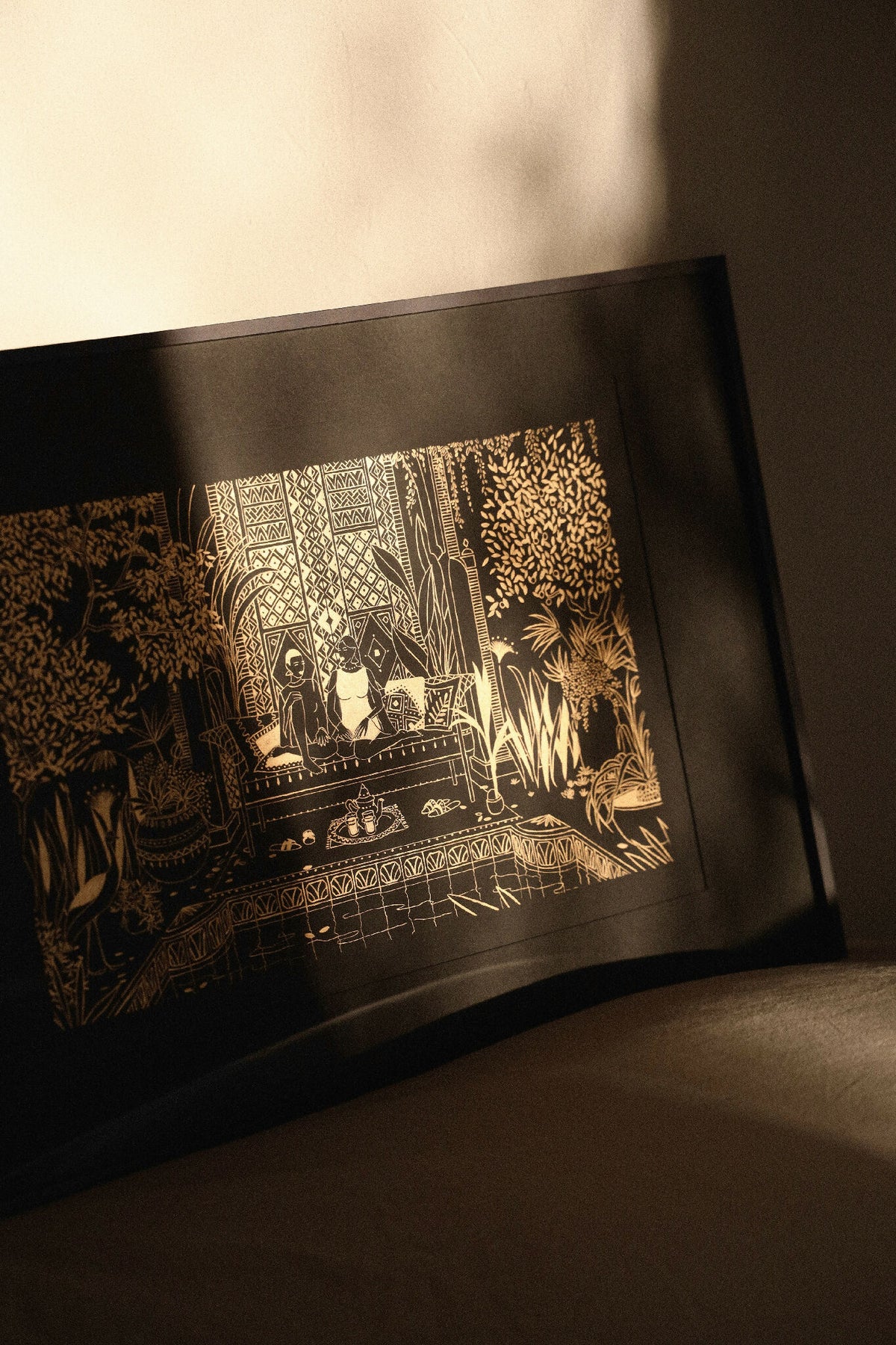 Sérigraphie encadrée au motif or sur fond sombre, scène décorative et végétale