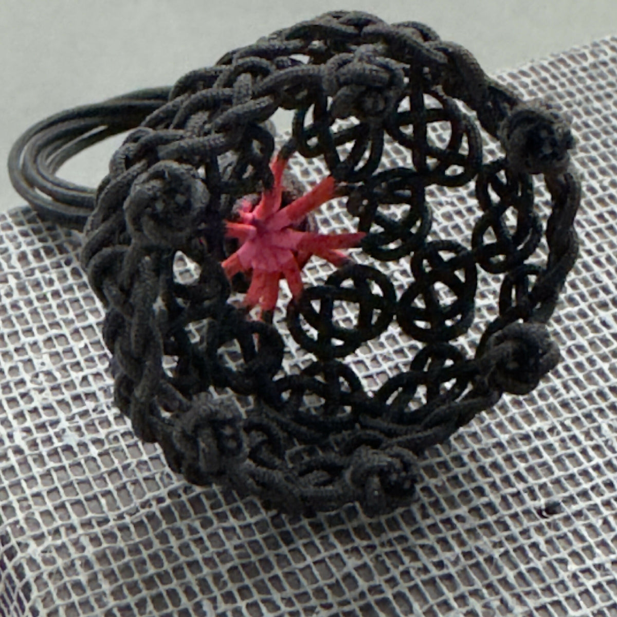 Bague noire résille, gros plan sur étoile rouge centrale
