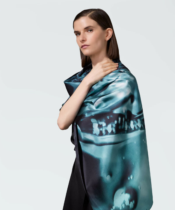 Écharpe en satin turquoise à motif abstrait, portée sur une épaule