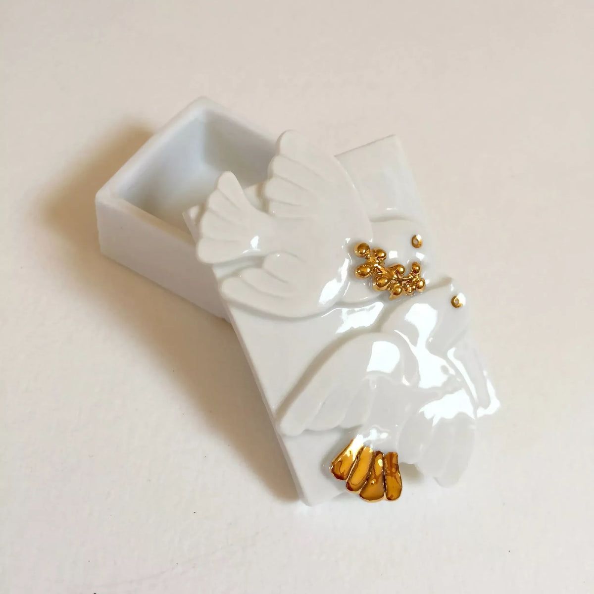 Boîte à bijoux blanche en forme de colombe, plateau intérieur et détails dorés.