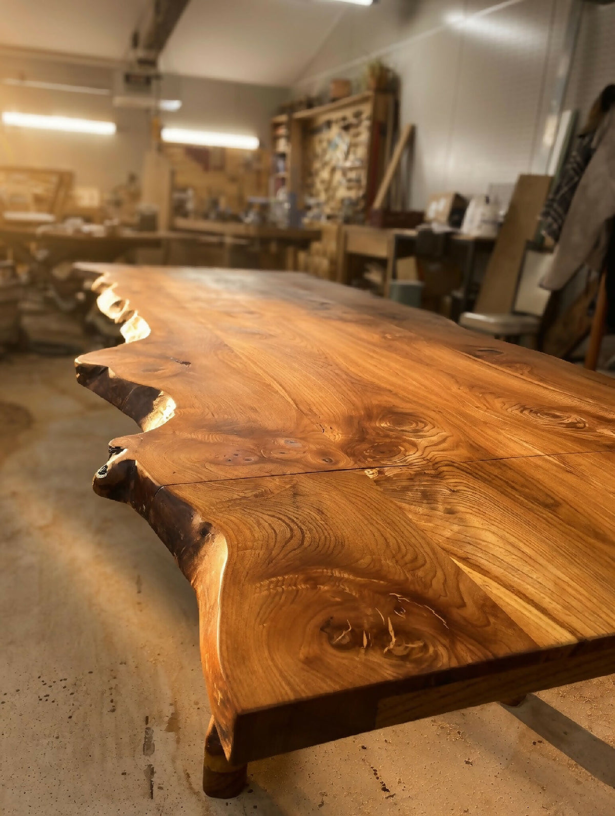 Table en bois massif, plateau épais aux bords irréguliers et veinage marqué.