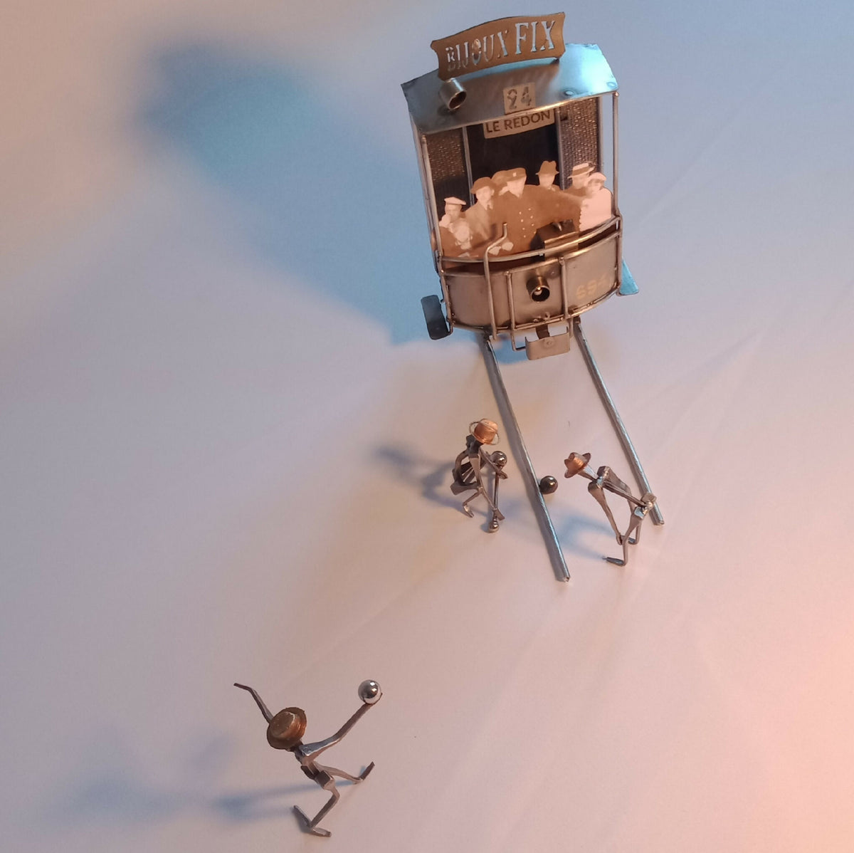 Sculpture miniature en métal avec cabine vitrée et trois petites figurines