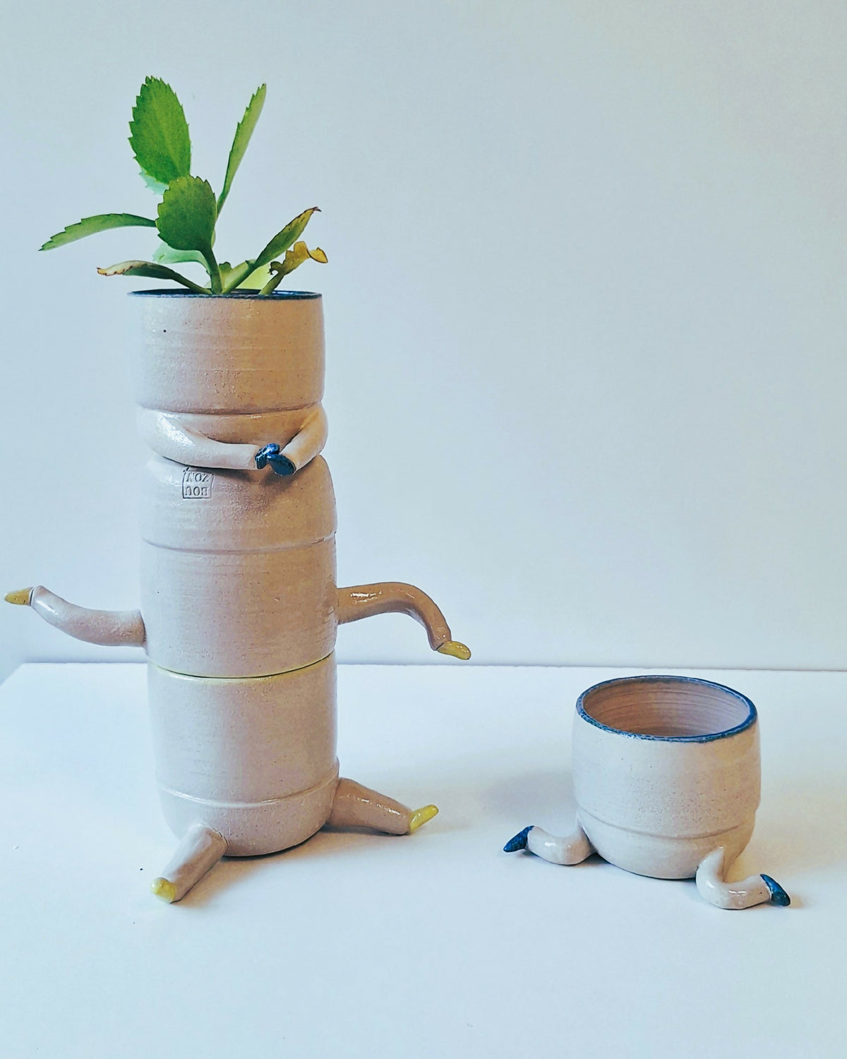 Pot figuratif en céramique blanche avec plante verte et petit pot