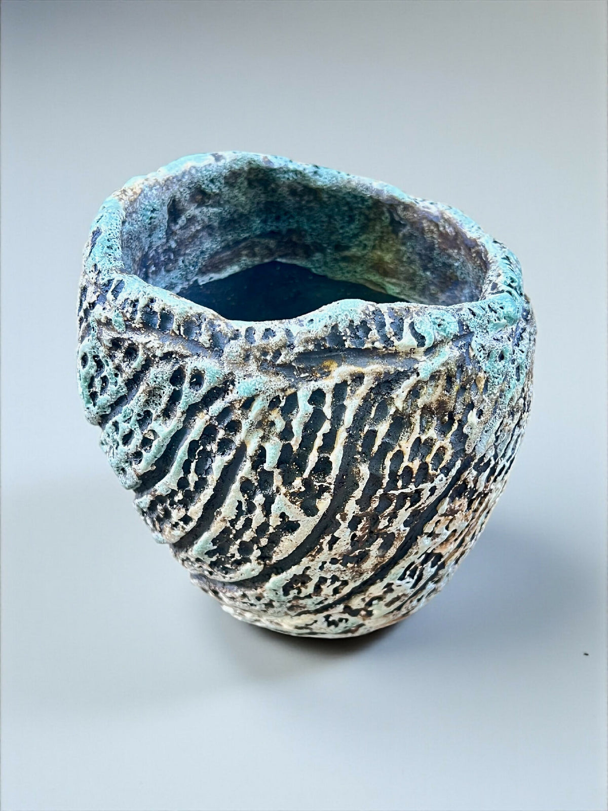 Pot en grès sculpté, vue de dessus partielle, rebord bleu-vert texturé