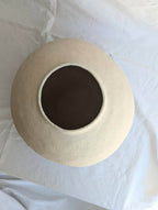 Vase en céramique beige vue de dessus, ouverture circulaire bordée.