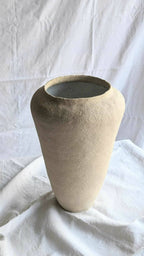 Vase beige en forme conique avec large ouverture circulaire, intérieur sombre.