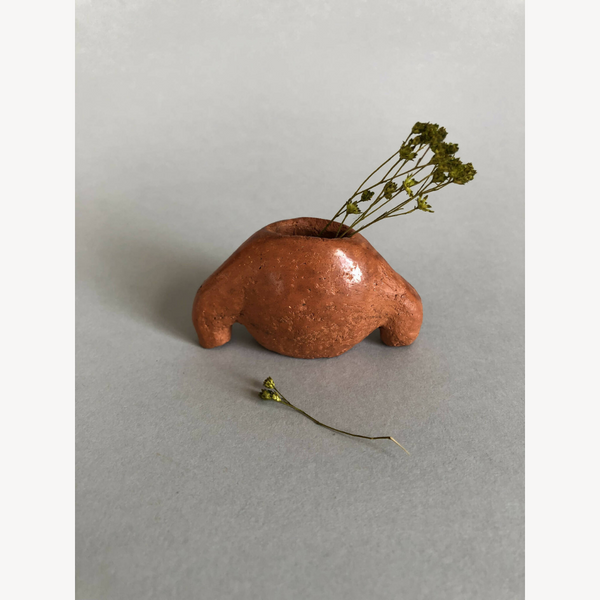 Mini vase en forme de coquillage brun cuivré, avec herbes sèches en bouquet.