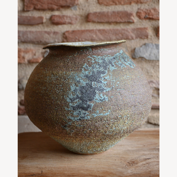 Vase en céramique marron, éclats bleus, bec fin et panse arrondie.