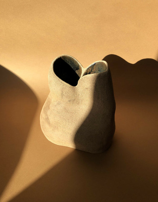 Vase sculptural beige à ouverture ovale noire, forme asymétrique