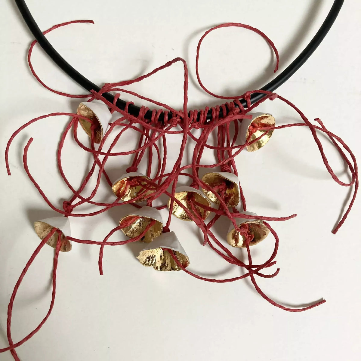 Collier cordon noir, pendentifs fleurs dorées et fils rouges torsadés