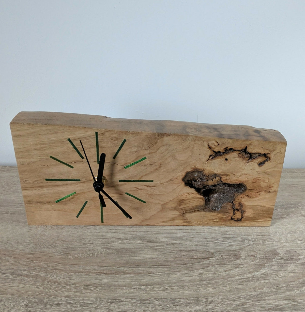 Horloge de bureau en bois clair avec aiguilles noires et repères verts sur le cadran.
