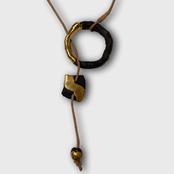 Collier avec anneau noir et pendentif doré, cordon beige noué